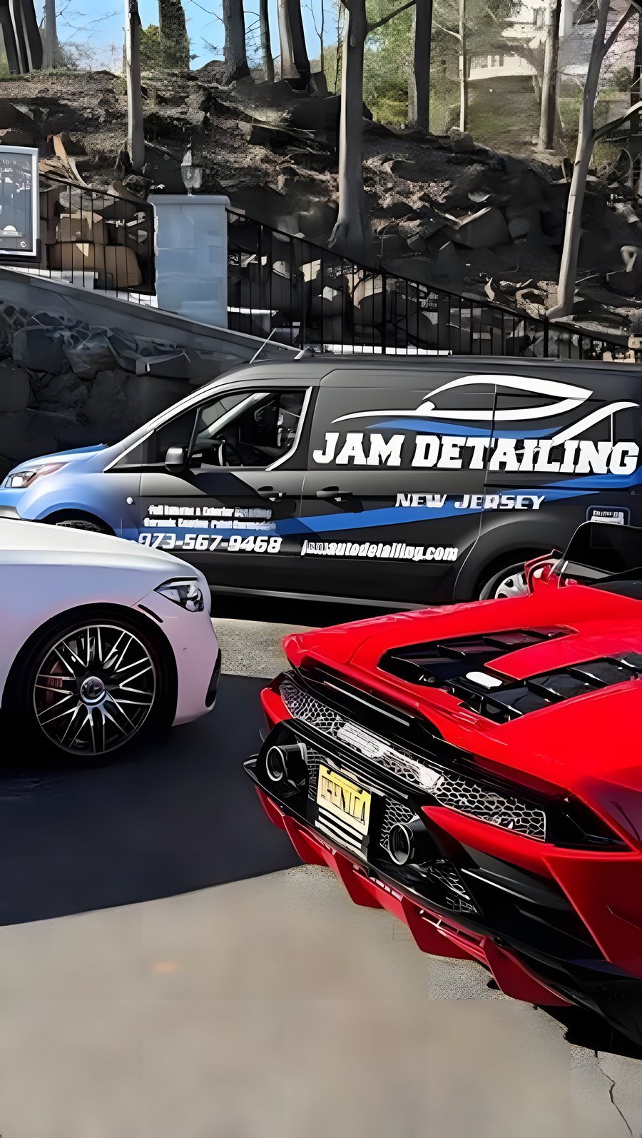 The JAM van parked beside a red Lamborghini and a white Mercedes